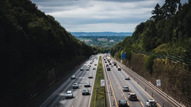 Autobahn durch ein bewaldetes Tal in Deutschland – Anreise mit dem Auto zum Flughafen Berlin (BER)