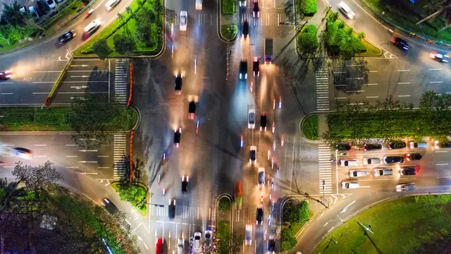 Beleuchtete Straßenkreuzung bei Nacht von oben – Anreise mit dem Auto zum Flughafen Hannover