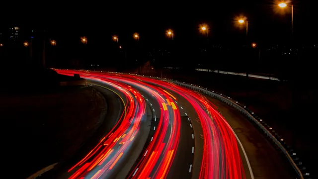 Rote Lichtspuren von Autos auf einer Straße bei Nacht – Anreise mit dem Auto zum Flughafen Memmingen