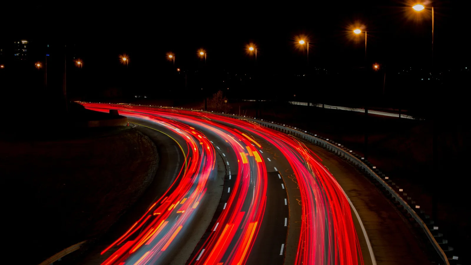 Traînées lumineuses rouges de voitures sur une route la nuit – se rendre en voiture à l'aéroport de Memmingen