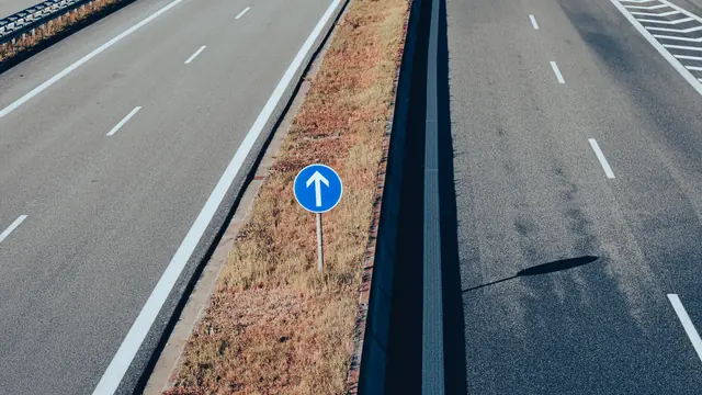 Leere Schnellstraße mit blauem Richtungsschild – Anreise mit dem Auto zum Flughafen Nürnberg