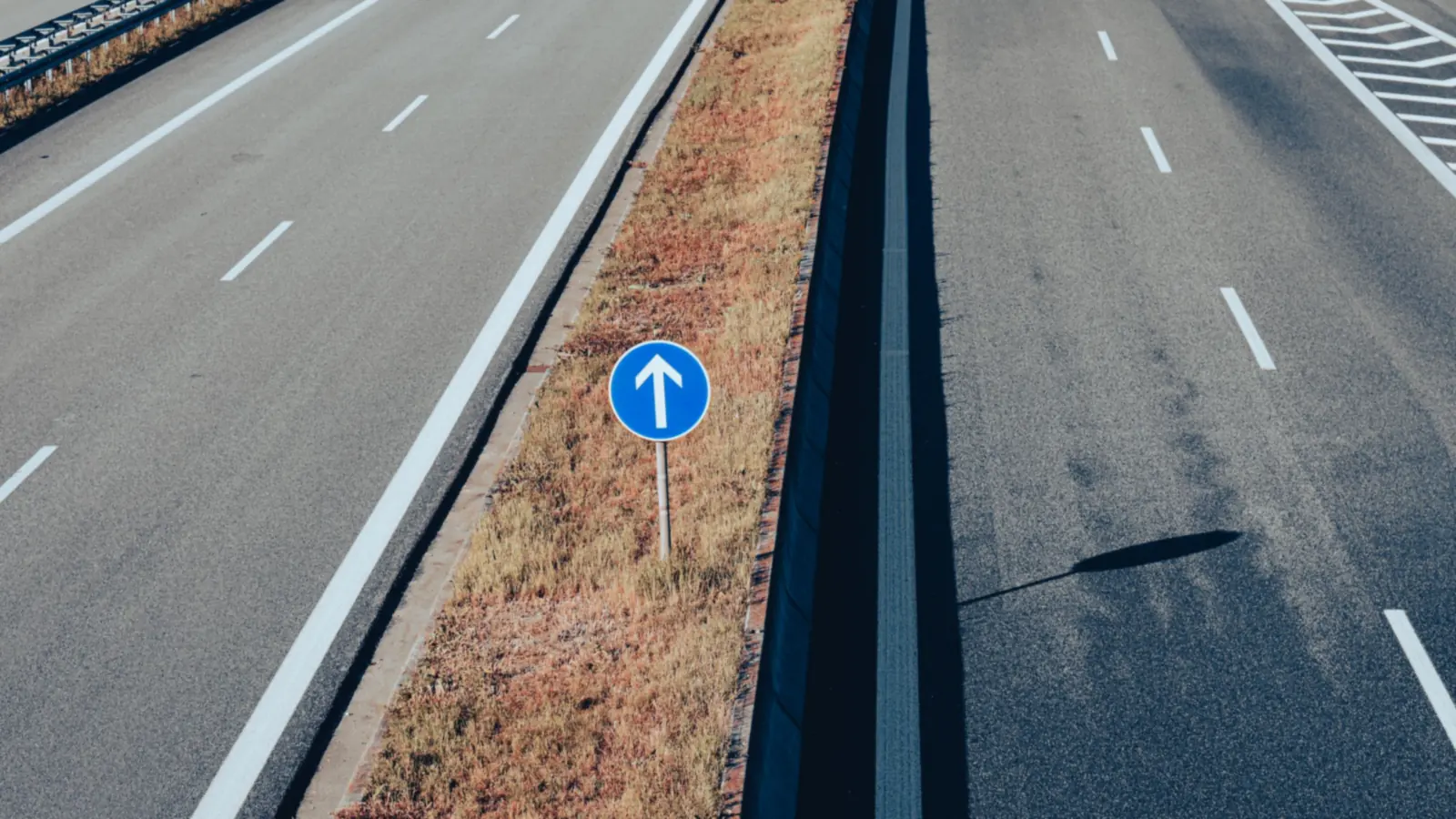 Empty expressway with a blue direction sign – driving to Nuremberg Airport