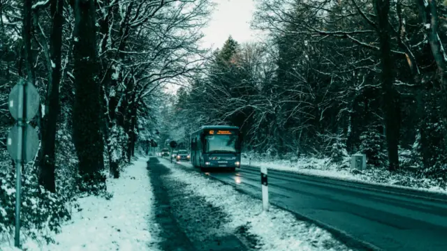 Linienbus auf einer verschneiten Straße – Bus oder Auto zum Flughafen Dortmund
