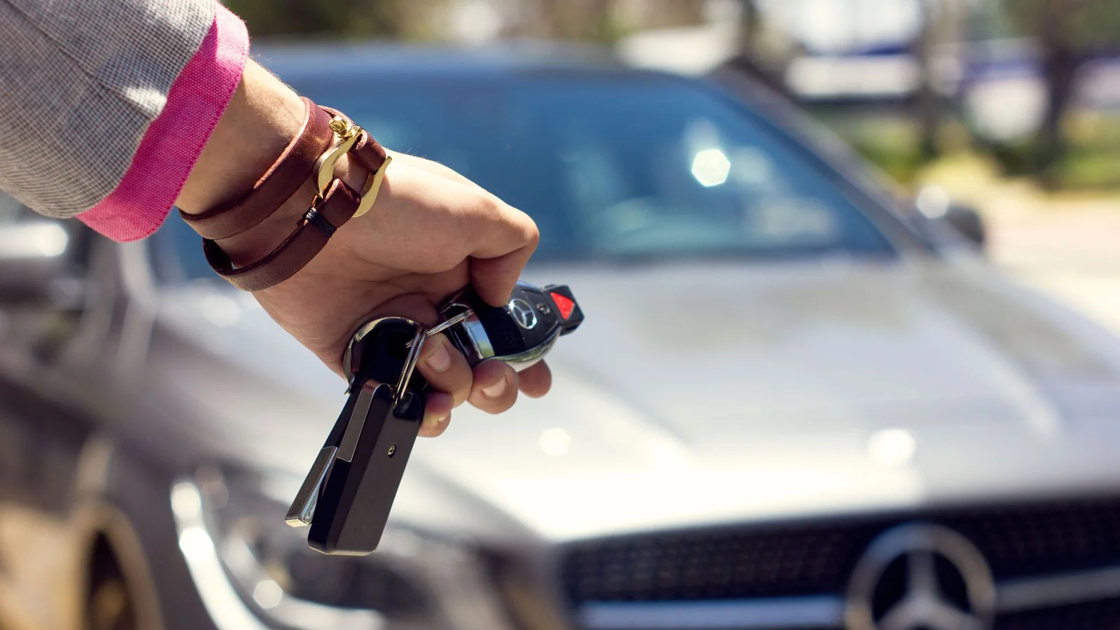 Vrouw opent een auto met de afstandsbediening – voertuigoverdracht op luchthaven Hannover