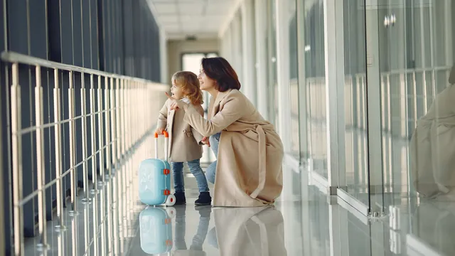 Mutter und Kind schauen aus dem Fenster – mit Familie und Gepäck zum Flughafen Dortmund