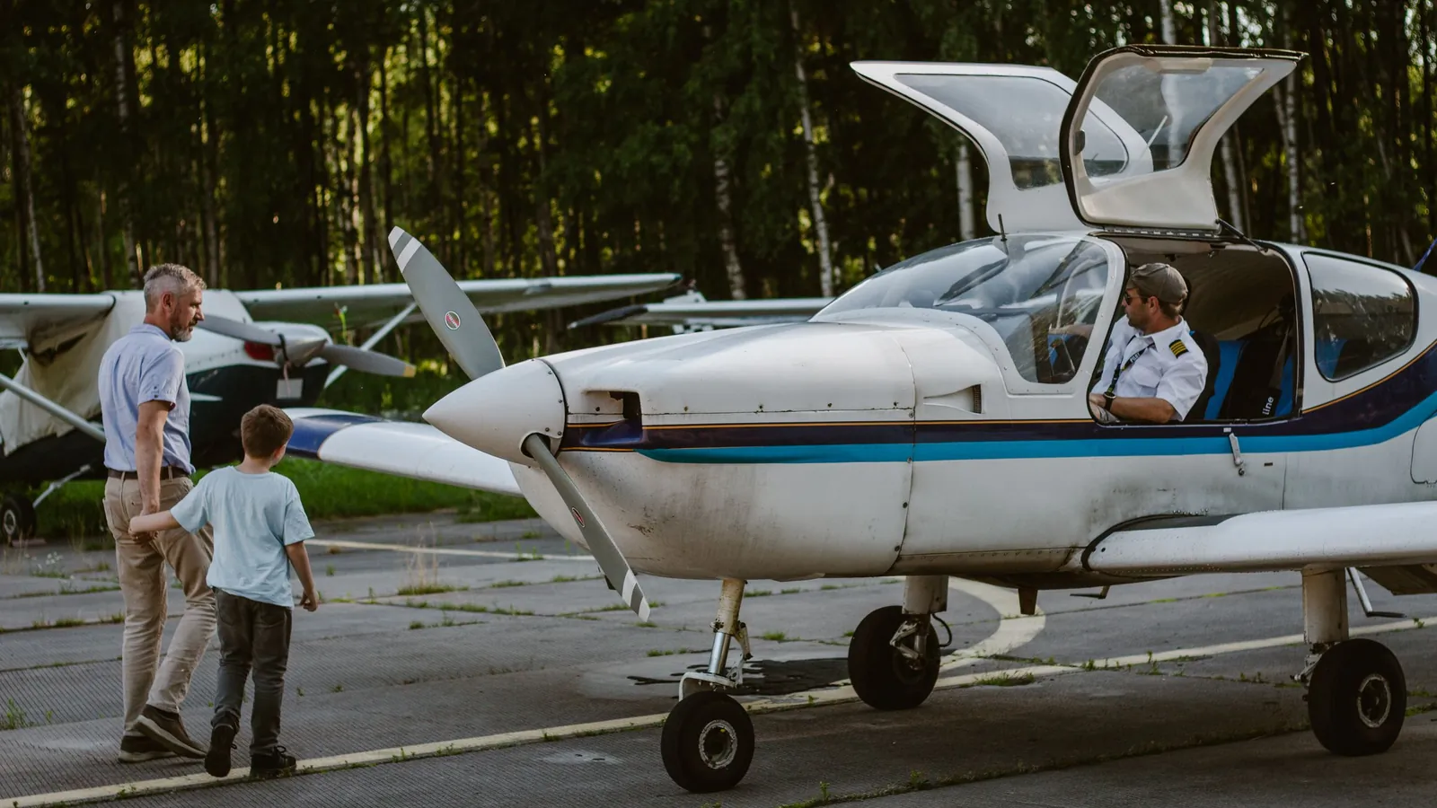 Vader en zoon naast een klein vliegtuig – met gezin en bagage naar luchthaven Karlsruhe/Baden-Baden