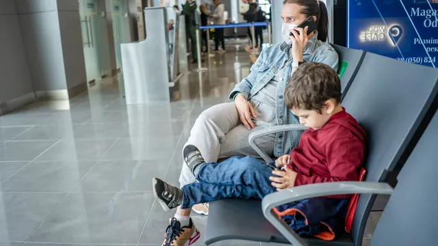 Mutter und Sohn warten im Wartebereich – mit Familie und Gepäck zum Flughafen Stuttgart