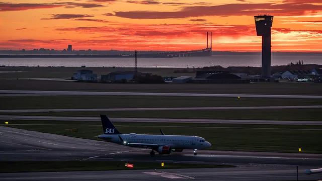 Flugzeug auf dem Rollfeld vor Tower im Morgenrot – Frühflug ab Flughafen Düsseldorf