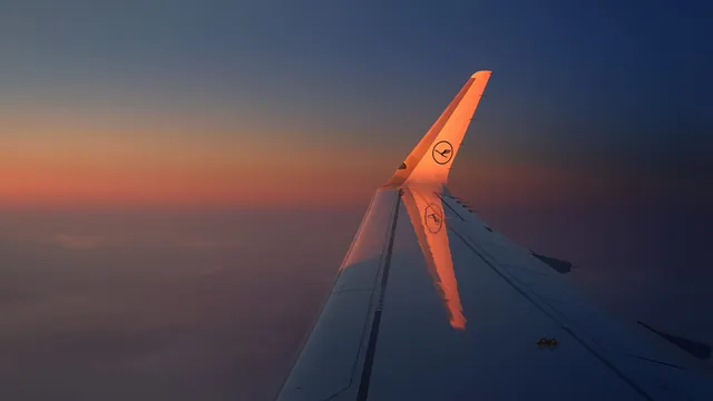 Flugzeugflügel über den Wolken in der Morgendämmerung – Parken für den Frühflug am Flughafen Berlin (BER)