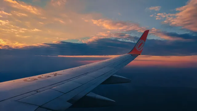 Blick aus dem Flugzeugfenster auf die Tragfläche in der Morgendämmerung – Parken für den Frühflug am Flughafen Hamburg