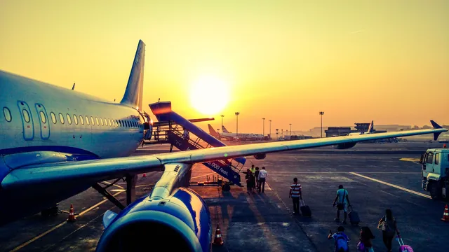 Passagierflugzeug mit Fluggasttreppe im Sonnenaufgang – Parken für den Frühflug am Flughafen München
