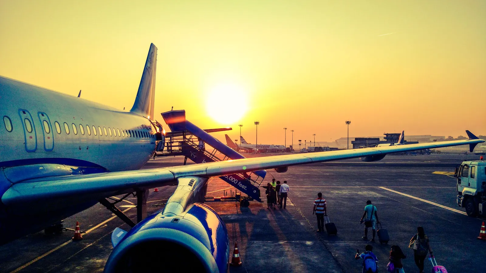 Passenger aircraft with boarding stairs at sunrise – parking for an early flight at Munich Airport