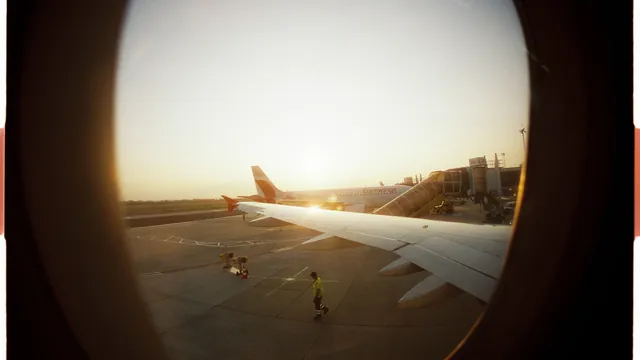 Blick durch das Flugzeugfenster auf das Vorfeld im Morgenlicht – Parken für den Frühflug am Flughafen Stuttgart