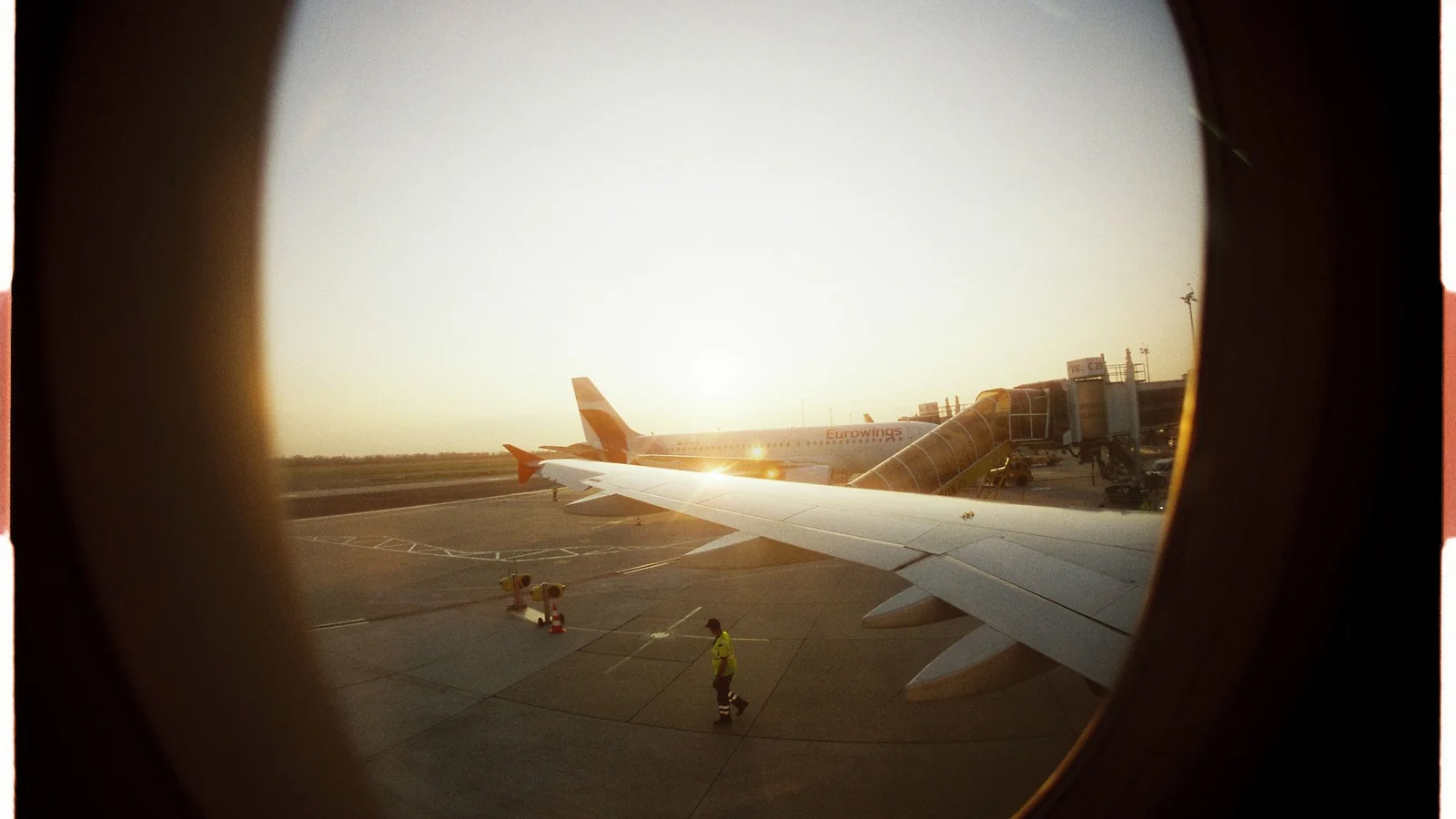 Vue par le hublot sur le tarmac dans la lumière du matin – stationnement pour un vol matinal à l'aéroport de Stuttgart
