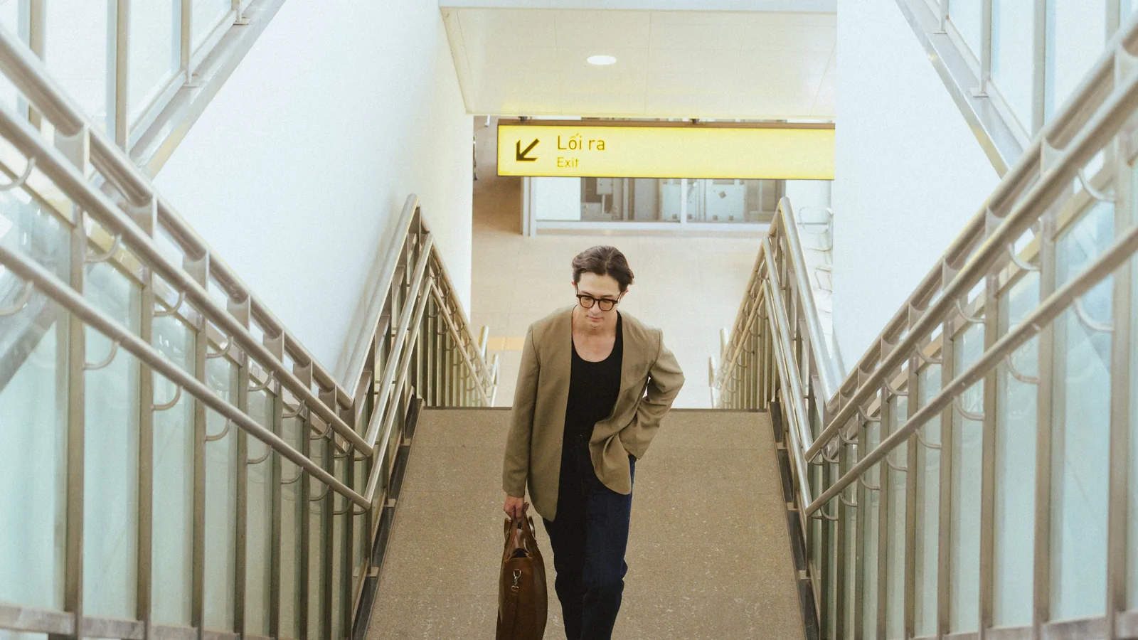Businesswoman with a bag on a staircase at the airport – parking for business trips at Berlin (BER) Airport