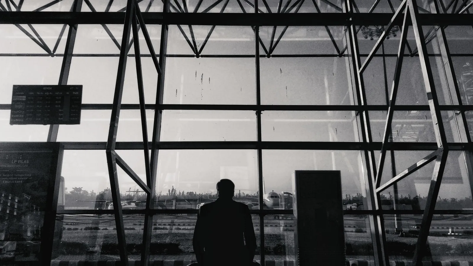 Silhouette of a traveller in front of a glass façade – parking for business trips at Memmingen Airport