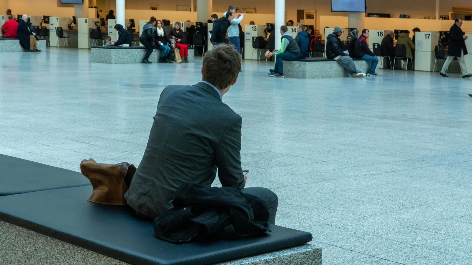 Voyageur d'affaires sur un banc dans le terminal – stationnement pour les voyages d'affaires à l'aéroport de Munich