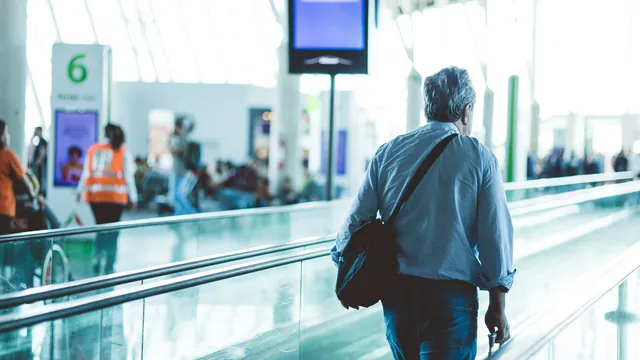 Reisender auf dem Laufband im Terminal – Parken für Geschäftsreisen am Flughafen Stuttgart