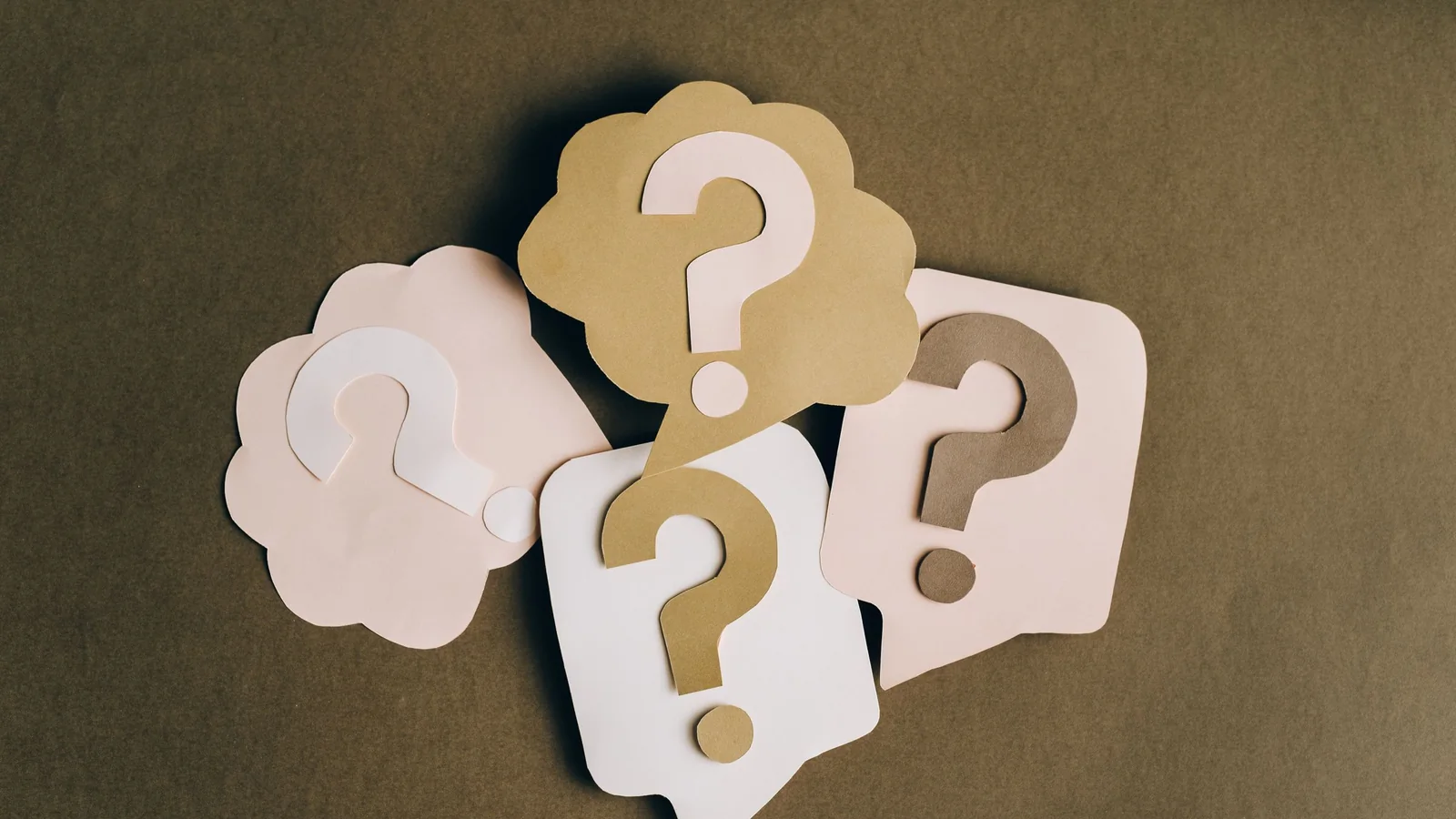 Bulles en papier avec des points d'interrogation – questions fréquentes sur le stationnement à l'aéroport de Berlin (BER)