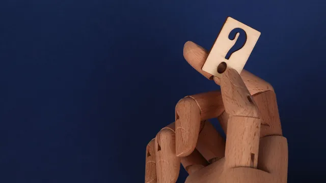 Holzhand hält ein Fragezeichen – häufige Fragen zum Parken am Flughafen Hamburg