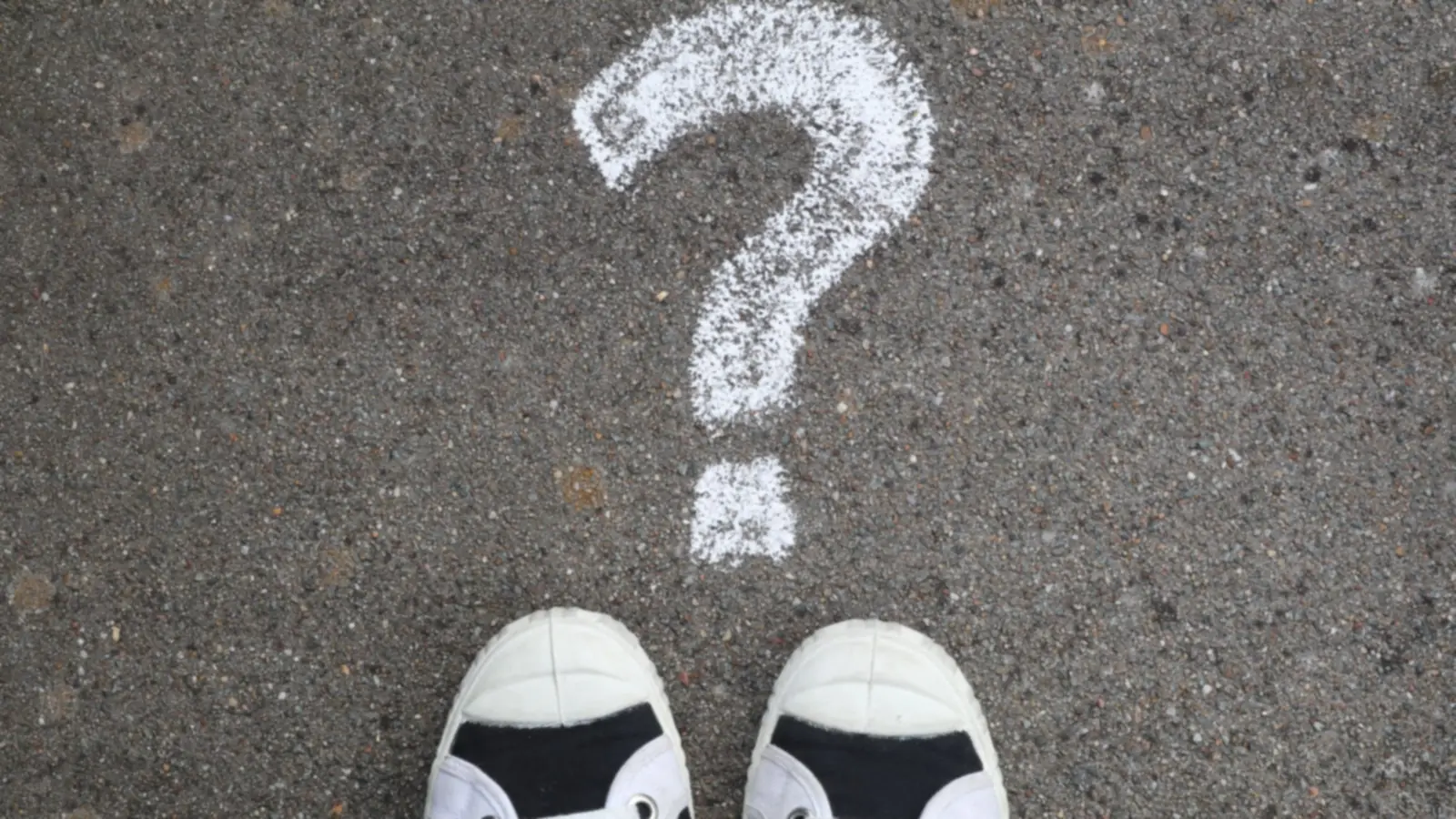 Point d'interrogation dessiné à la craie devant deux chaussures – questions fréquentes sur le stationnement à l'aéroport de Munich