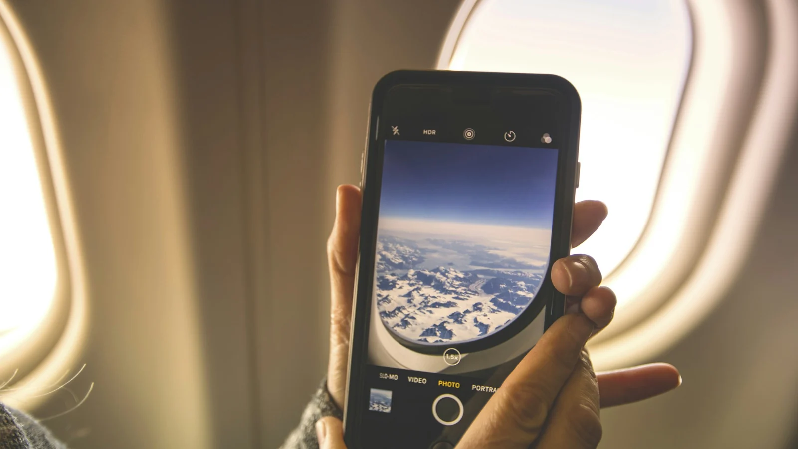 Smartphone vor dem Flugzeugfenster – Parkplatz am Flughafen Frankfurt kurzfristig buchen