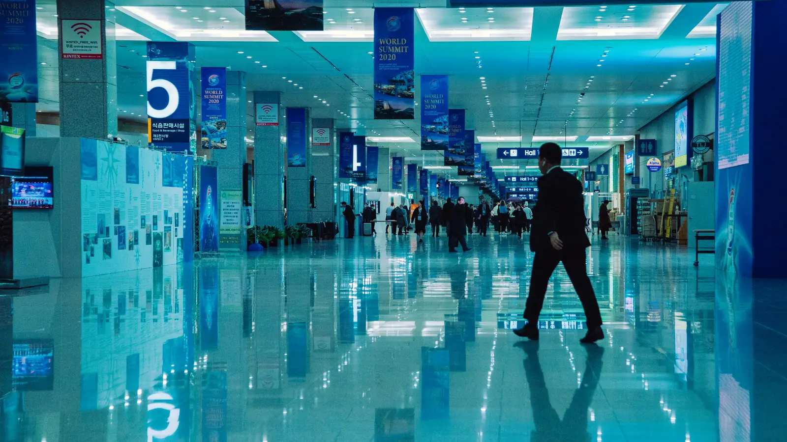 Traveller in a hall with signs to halls 1 to 5 – trade fair parking at Stuttgart Airport