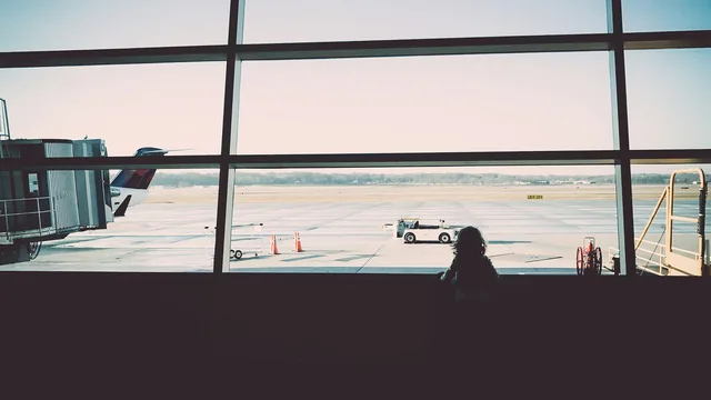Kind schaut durch die Terminalscheibe auf das Vorfeld – mit Kindern am Flughafen Frankfurt