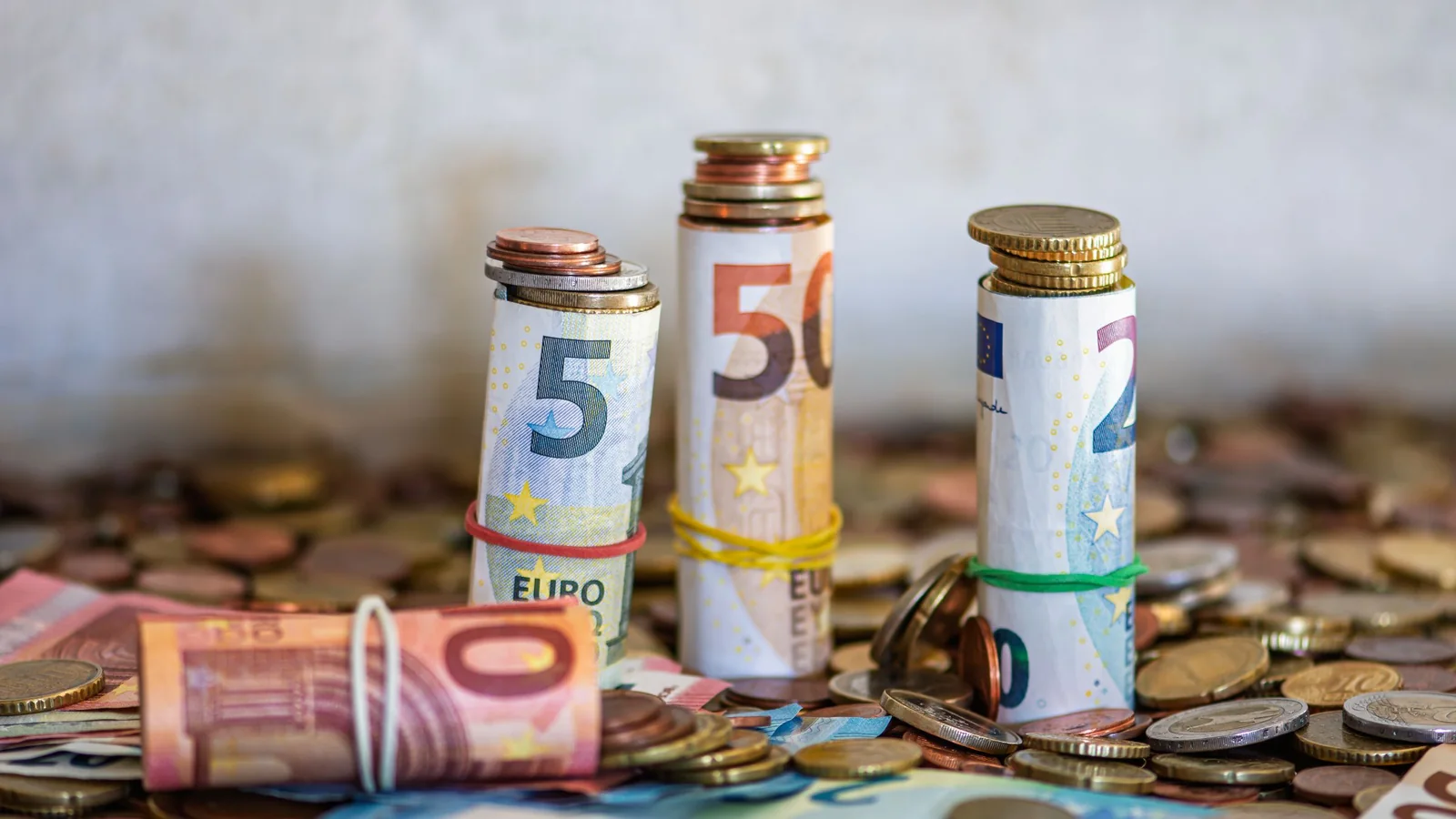 Rolled euro banknotes on coins – comparing parking costs at Karlsruhe/Baden-Baden Airport