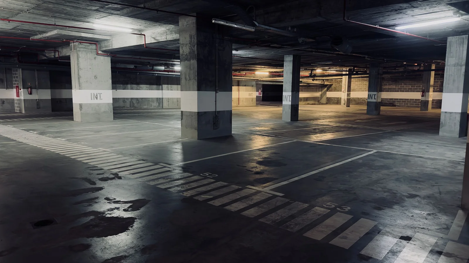 Empty underground car park with a wet floor – parking options at Memmingen Airport