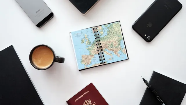 Reiseplanung mit Karte, Kaffee, Reisepass und Smartphones – Parkplatz am Flughafen Hamburg reservieren