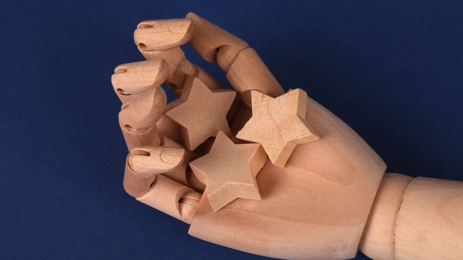 Wooden hand holding wooden stars – choosing a parking service at Stuttgart Airport
