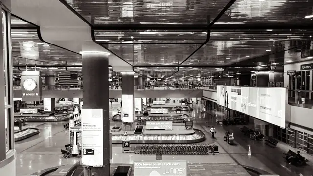 Gepäckausgabe in einer Flughafenhalle in Schwarz-Weiß – nach der Rückkehr das Auto am Flughafen Dortmund abholen
