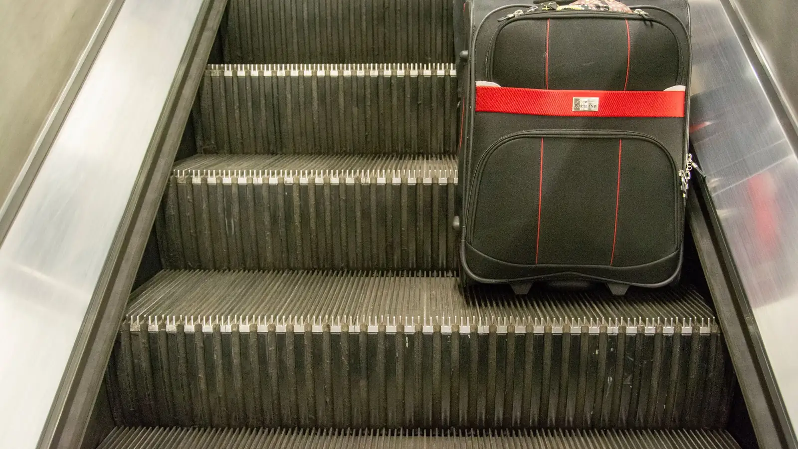Valise sur un escalator – récupérer la voiture à l'aéroport de Hanovre au retour