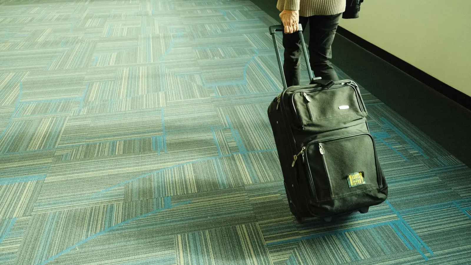 Voyageur tirant une valise dans un couloir d'aéroport – récupérer la voiture à l'aéroport de Cologne/Bonn au retour