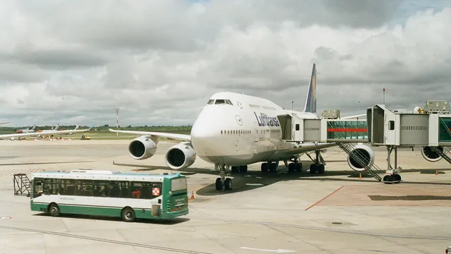 Bus vor einem Flugzeug an der Fluggastbrücke – Shuttle-Parken am Flughafen Hamburg