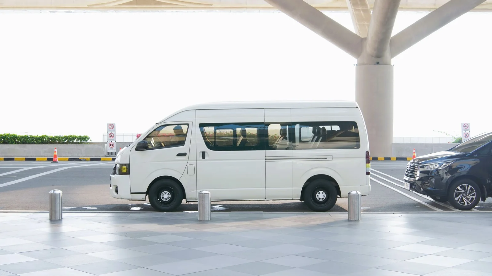 Minibus blanc devant un terminal moderne – parking avec navette à l'aéroport de Cologne/Bonn