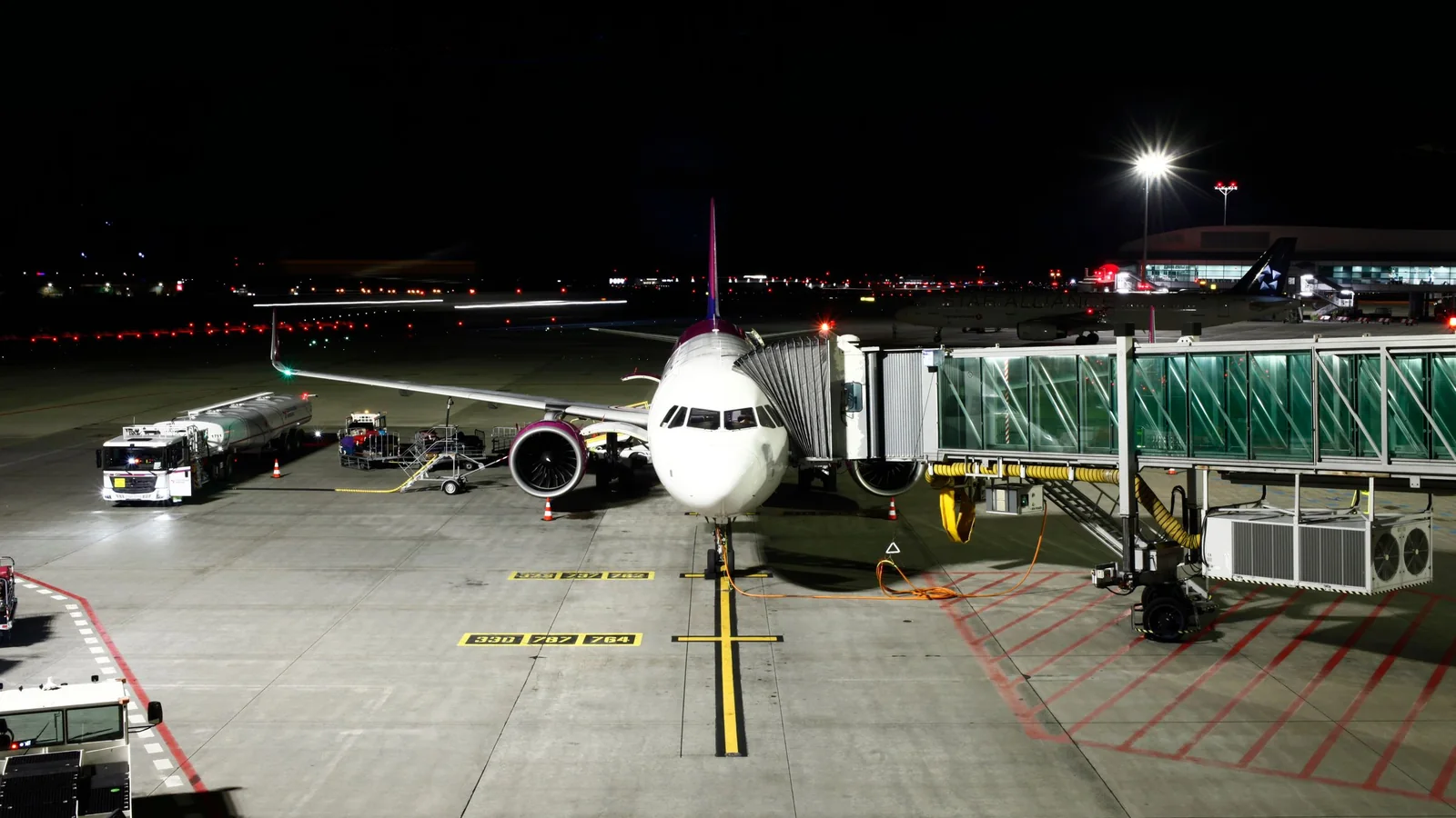 Aircraft at the jet bridge at night – late arrival at Hamburg Airport