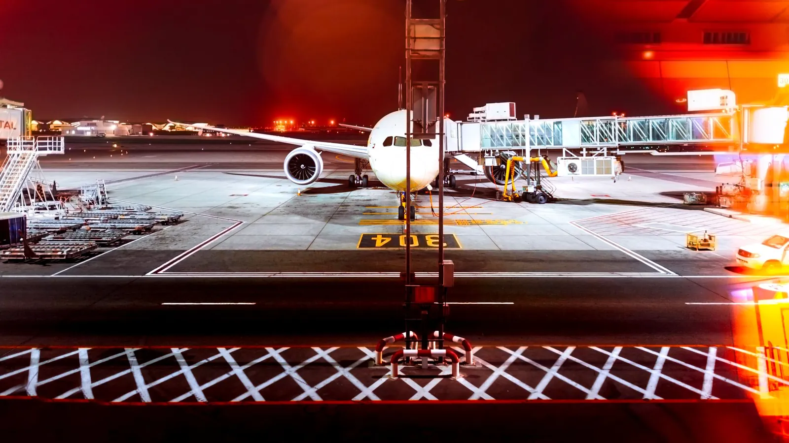 Avion au poste de stationnement la nuit sous des lumières rouges – arrivée tardive à l'aéroport de Hanovre