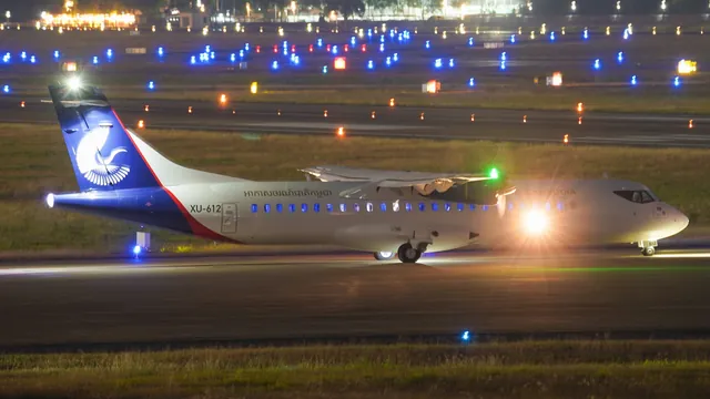 Turboprop-Flugzeug rollt nachts zwischen den Rollbahnlichtern – späte Ankunft am Flughafen Karlsruhe/Baden-Baden
