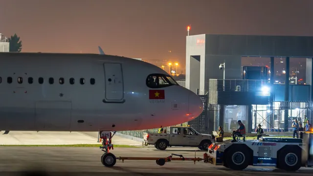 Flugzeug mit Schlepper auf dem Vorfeld am Abend – späte Ankunft am Flughafen Memmingen