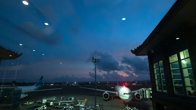 Flugzeug am Terminal bei Nacht, Blick aus dem Gebäude – späte Ankunft am Flughafen München
