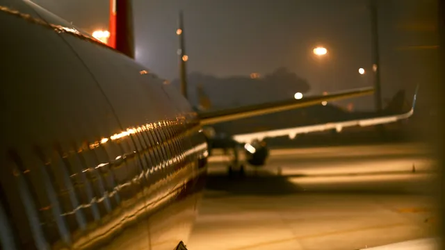 Spiegelungen am Flugzeugrumpf bei Nacht – späte Ankunft am Flughafen Nürnberg