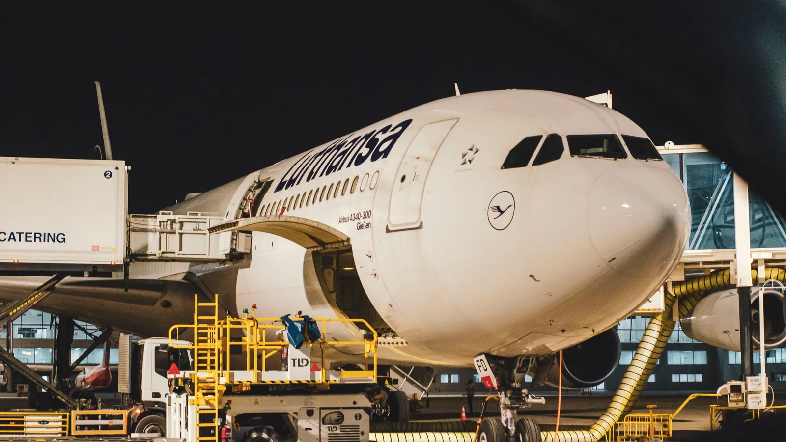 Avion éclairé au terminal la nuit avec des véhicules de piste – arrivée tardive à l'aéroport de Stuttgart
