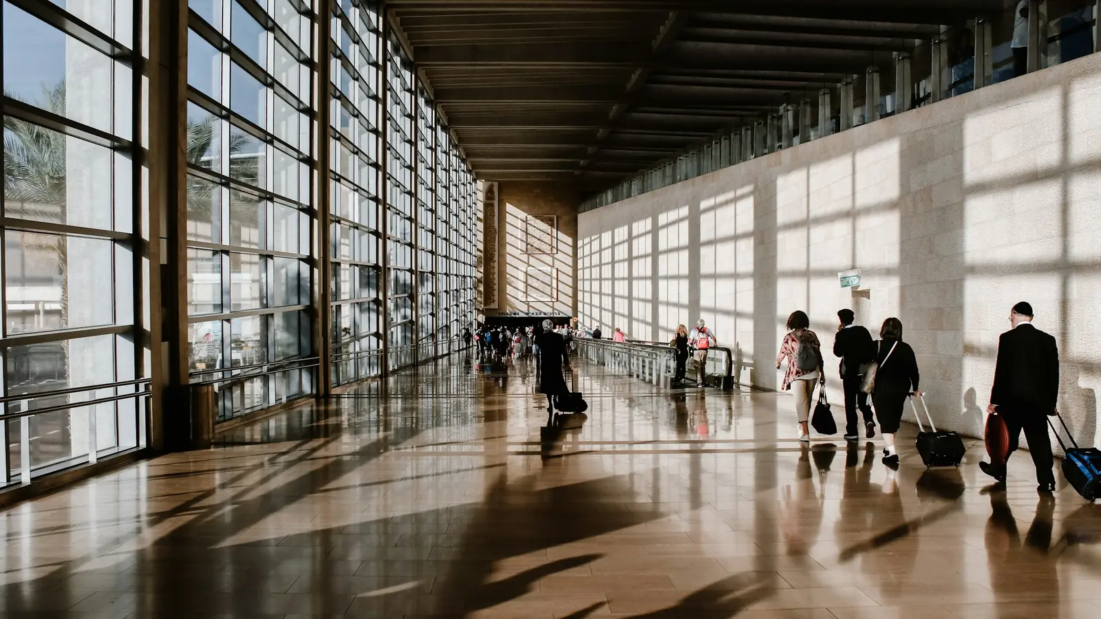 Reisende mit Koffern in einem langen Terminalgang – Streik am Flughafen Frankfurt