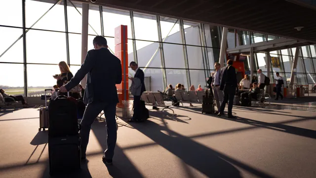 Reisende mit Koffern im lichtdurchfluteten Terminal – Orientierung im Terminal am Flughafen Memmingen