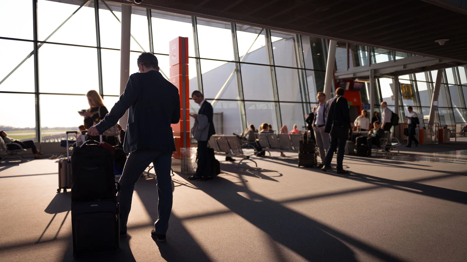 Reisende mit Koffern im lichtdurchfluteten Terminal – Orientierung im Terminal am Flughafen Memmingen