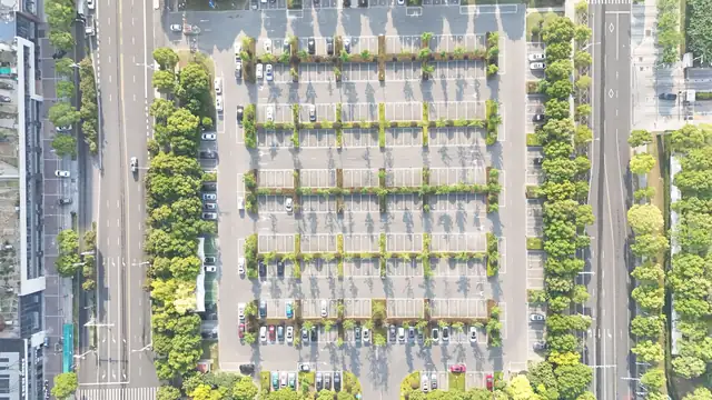 Parkplatz mit Baumreihen zwischen zwei Straßen von oben – Valet oder Shuttle am Flughafen Karlsruhe/Baden-Baden