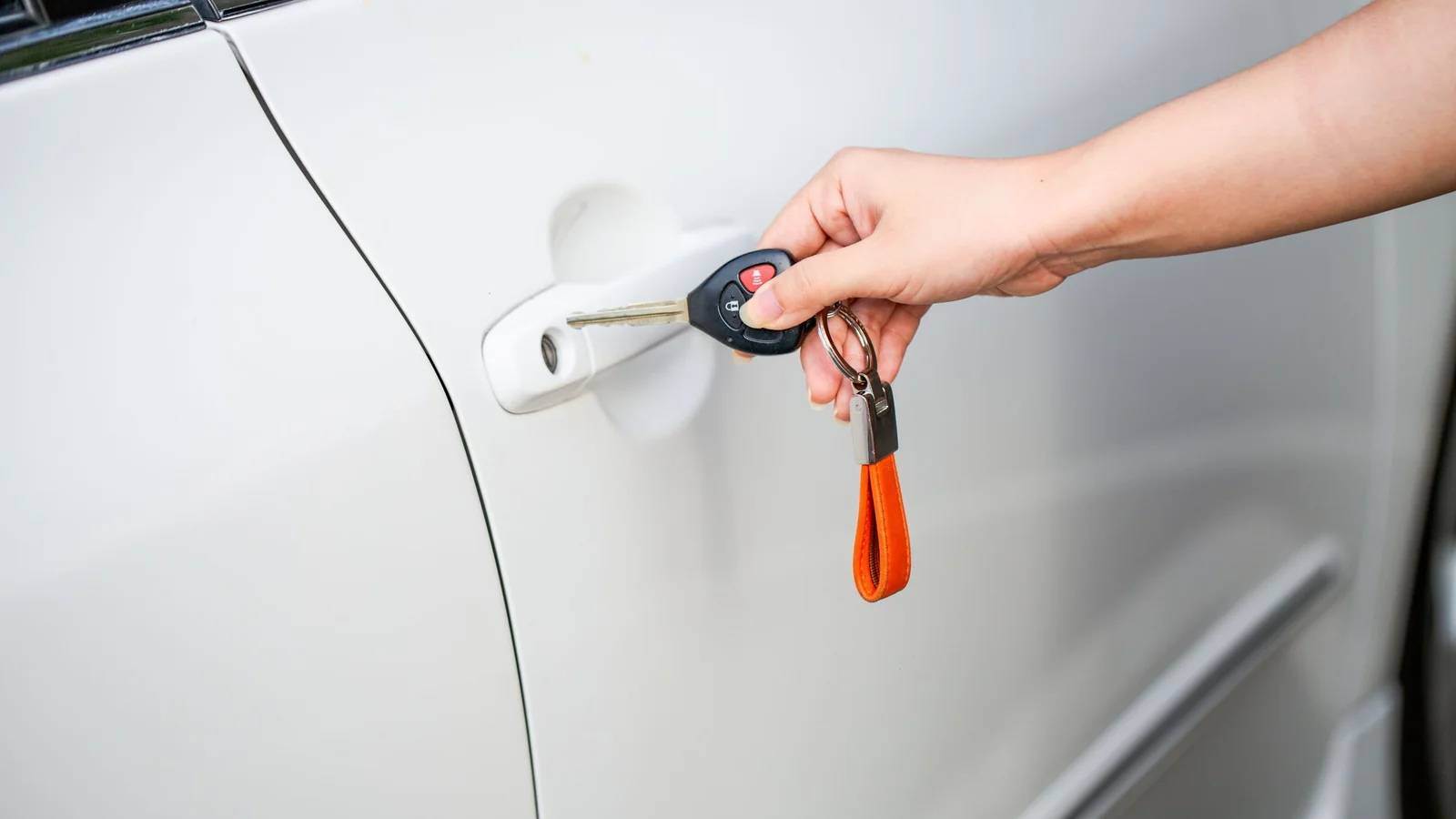 Hand mit Autoschlüssel an der Fahrertür – Valet Parking am Flughafen Memmingen